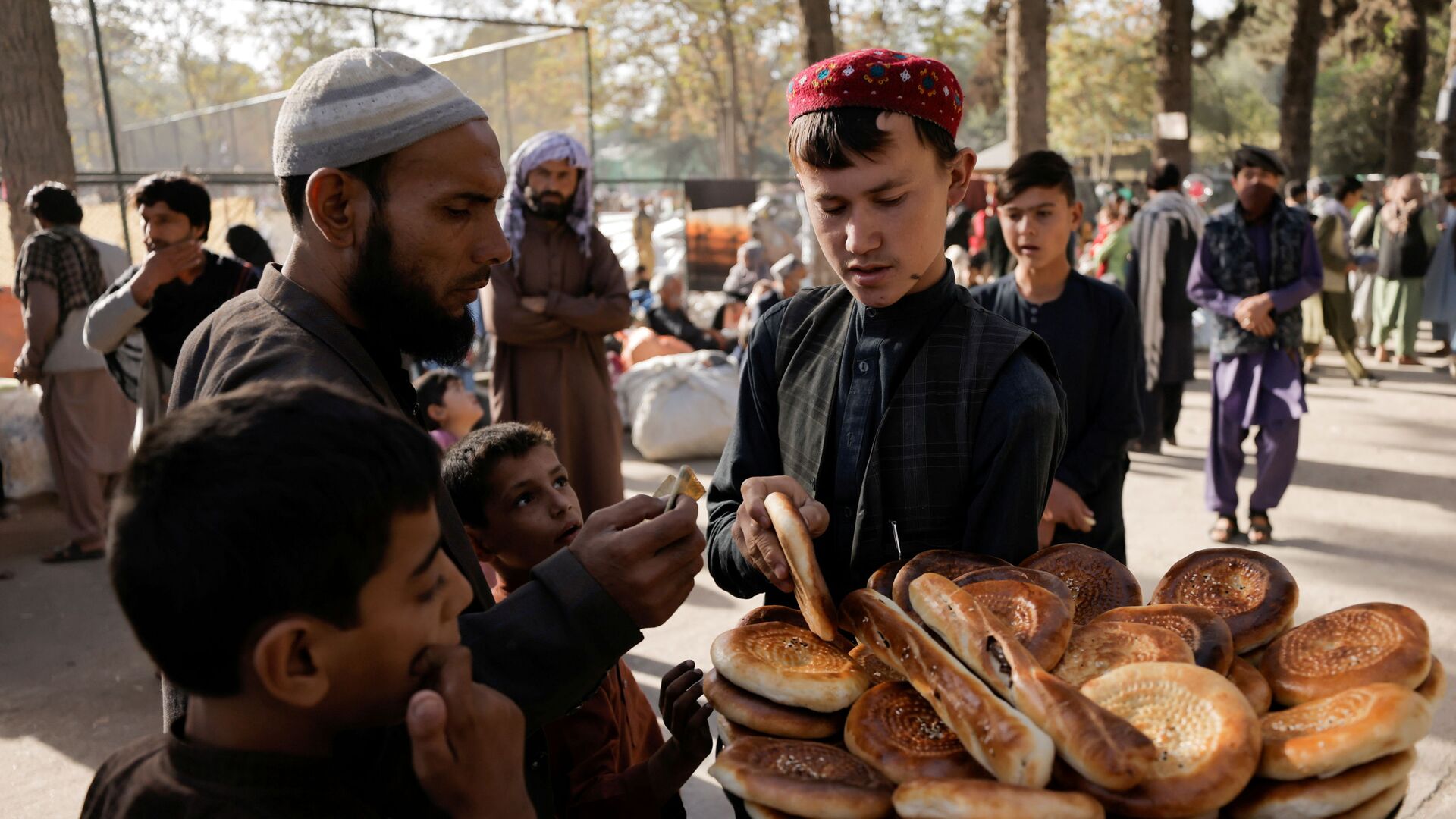 Мальчик продает хлеб во временном убежище для перемещенных афганских семей, спасающихся от насилия в своих провинциях, Кабул - Sputnik Moldova, 1920, 21.10.2021