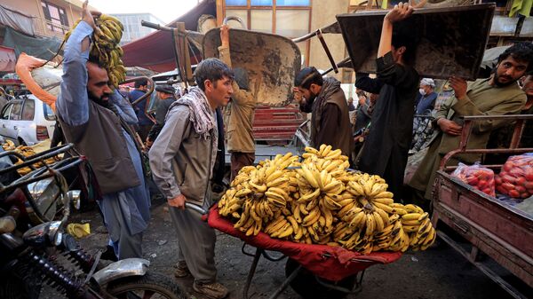 Мужчина толкает тачку с бананами на рынке в Кабуле - Sputnik Moldova-România