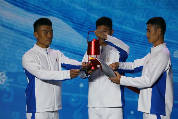 Participanții transferă flacăra olimpică de la lampa de siguranță la torță în cadrul ceremoniei de la Beijing, China, 20 octombrie 2021. - Sputnik Moldova