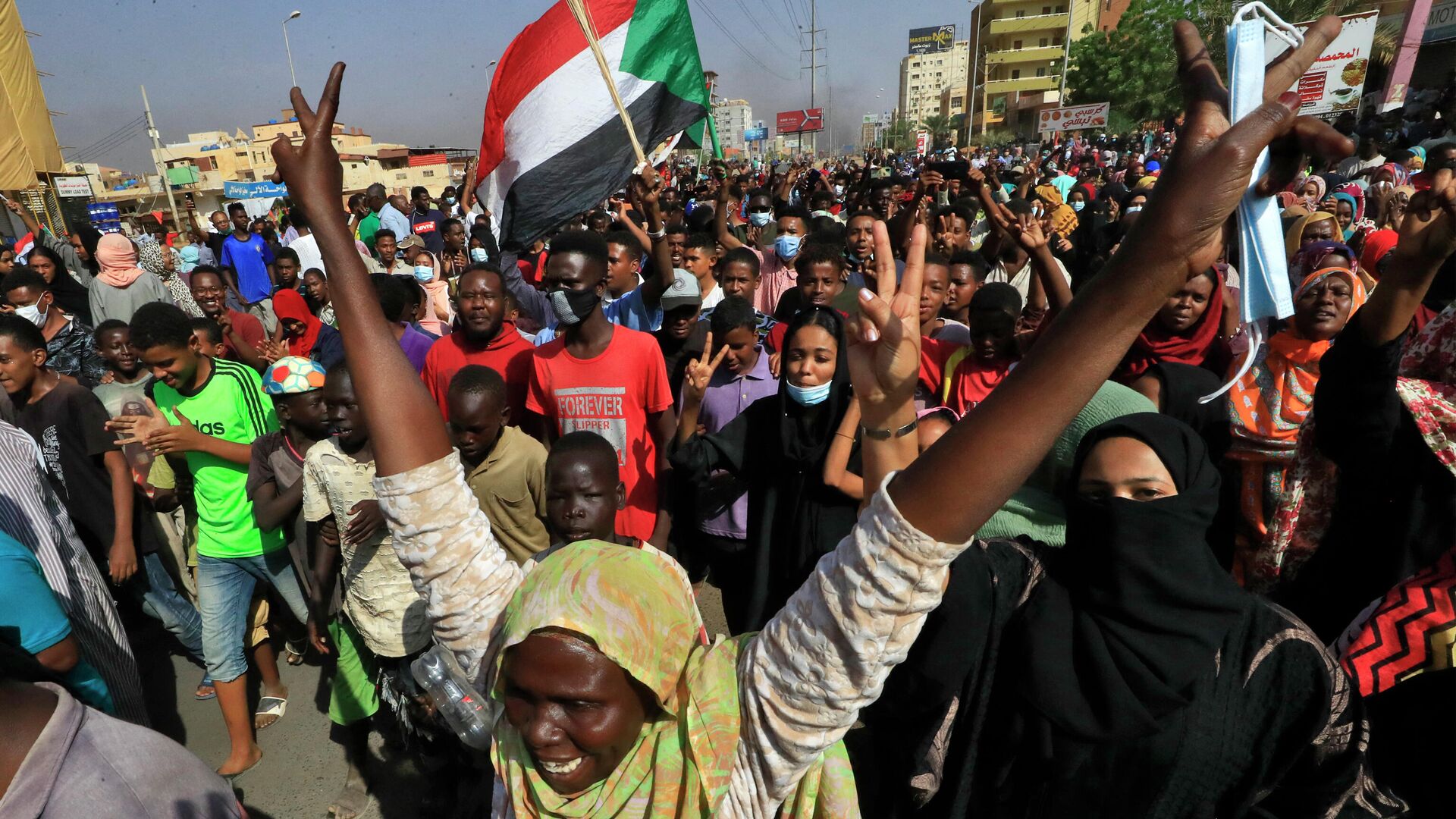 Суданские протестующие поднимают национальные флаги во время митинга на 60-й улице в столице Хартуме - Sputnik Moldova-România, 1920, 25.10.2021
