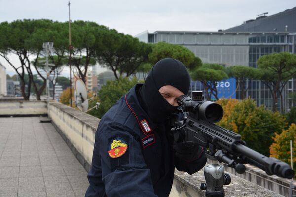 Lunetist din cadrul carabinierilor italieni, care monitorizează străzile de pe un acoperiș din apropierea centrului de convenții „La Nuvola” (în spate R) în cartierul EUR din Roma, înaintea Summitul mondial al liderilor G20. - Sputnik Moldova-România