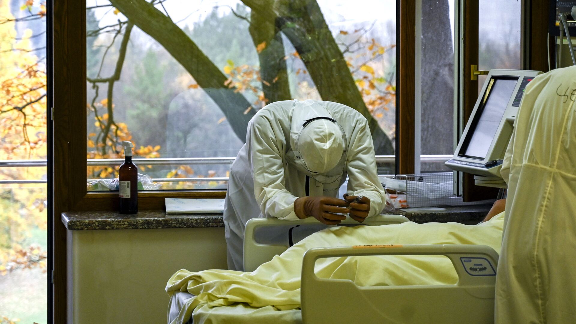 Медицинский работник рядом с пациентом в отделении интенсивной терапии больницы Лозенец в Софии - Sputnik Moldova-România, 1920, 18.11.2021