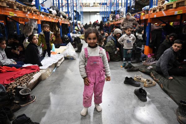 Fetiță, împreună cu alți refugiații din Orientul Mijlociu într-un centru de cazare temporară pentru migranți, echipat într-un centru logistic de la punctul de control Bruzgi de la granița belarusă-polonă. - Sputnik Moldova-România
