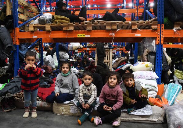 Refugiații din Orientul Mijlociu într-un centru de cazare temporară pentru migranți, echipat într-un centru logistic de la punctul de control Bruzgi de la granița belarusă-polonă. - Sputnik Moldova-România