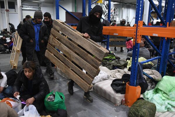 Refugiații din Orientul Mijlociu într-un centru de cazare temporară pentru migranți, echipat într-un centru logistic de la punctul de control Bruzgi de la granița belarusă-polonă. - Sputnik Moldova-România