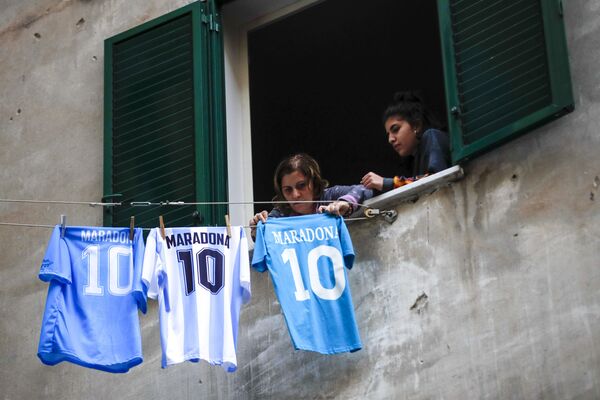 Женщина вешает майку Диего Марадоны в Неаполе. - Sputnik Молдова