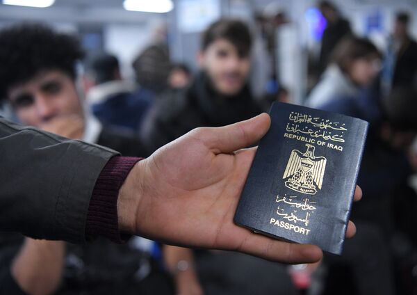 Иракский паспорт в руке одного из беженцев. - Sputnik Молдова