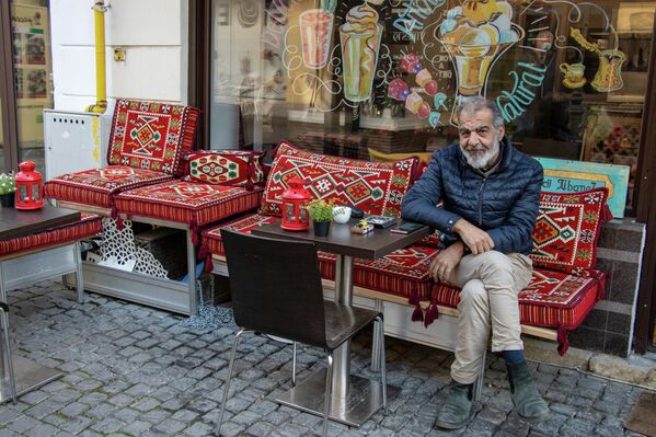 Un bătrân își bea cafeaua la o terasă din Centrul Vechi. - Sputnik Moldova-România