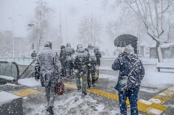 Oamenii își croiesc drum în timpul unui viscol puternic în cartierul Kadikoy din Istanbul, 17 februarie 2021. - Sputnik Moldova-România