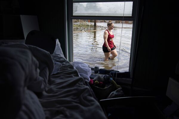 O persoană încearcă să pătrundă prin apă în casa avariată după inundațiile provocate de uraganului Ida, 1 septembrie 2021,  Jean Lafitte, Louisiana. - Sputnik Moldova-România