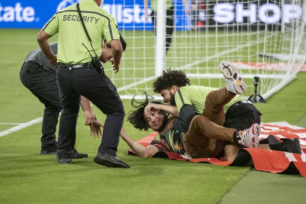 Охрана ловит фаната, выбежавшего на поле после международного товарищеского матча между Мексикой и Чили. - Sputnik Молдова