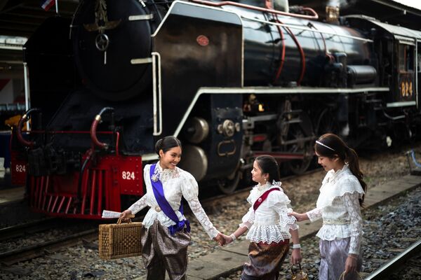 Женщины в старинных платьях позируют рядом с паровозом в Бангкоке, Таиланд. - Sputnik Молдова