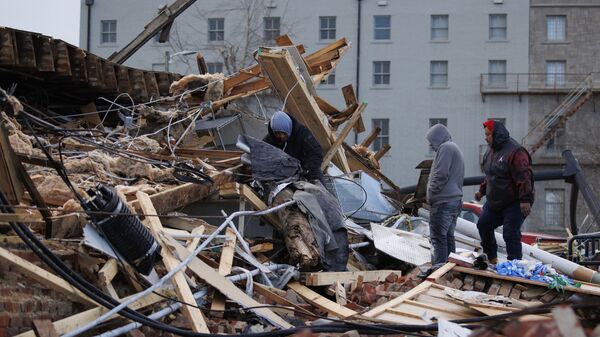 Люди обыскивают развалины здания, разрушенного торнадо в Мейфилде, Кентукки, США - Sputnik Молдова