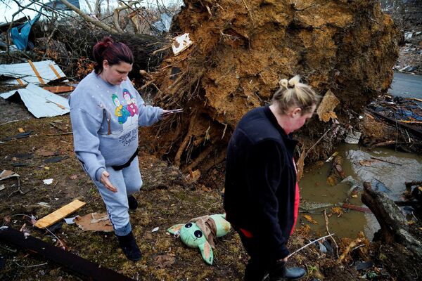 Amy Meno și Brooklyn Rogers caută bunuri după o izbucnire devastatoare de tornade care au zguduit mai multe state americane din Earlington, Kentucky, SUA, 11 decembrie 2021. - Sputnik Moldova-România