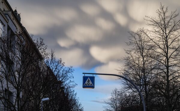 Norii de furtună se adună în spatele unui semn care indică o trecere de pietoni în Berlin, pe 11 martie 2021. - Sputnik Moldova-România