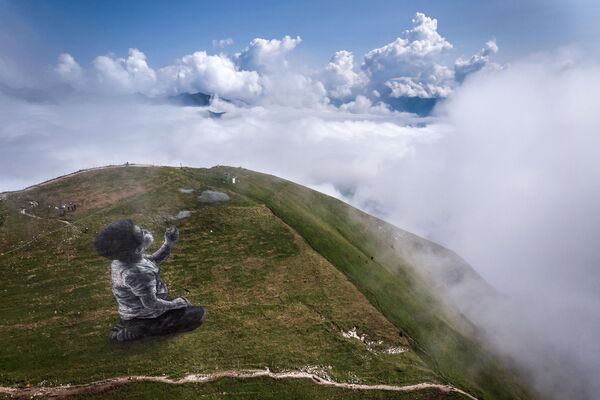 O fotografie arie realizată pe 24 august 2021 pe vârful muntelui Moleson, în Prealpii elvețieni, cu vedere la regiunea Gruyeres, arată o frescă uriașă land art a artistului francez Guillaume Legros, cunoscut sub numele de Saype, intitulată: „Un nou suflu &quot; reprezentând un băiat care sufla nori. - Opera de artă, care acoperă aproximativ 1500 de metri pătrați, a fost realizată cu vopsea biodegradabilă din cărbune de cretă, apă și proteine din lapte. - Sputnik Moldova-România