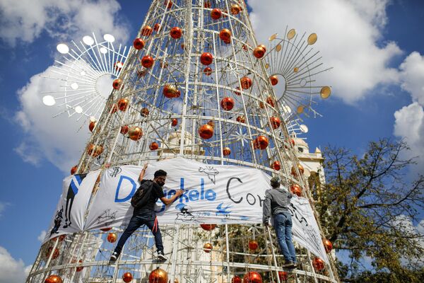 Активисты вешают баннер на елку во время акции протеста в Сан-Сальвадоре. - Sputnik Молдова