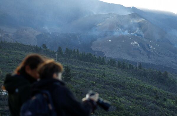 Два туриста на смотровой площадке Таджуя фотографируют вулкан Кумбре-Вьеха. - Sputnik Молдова