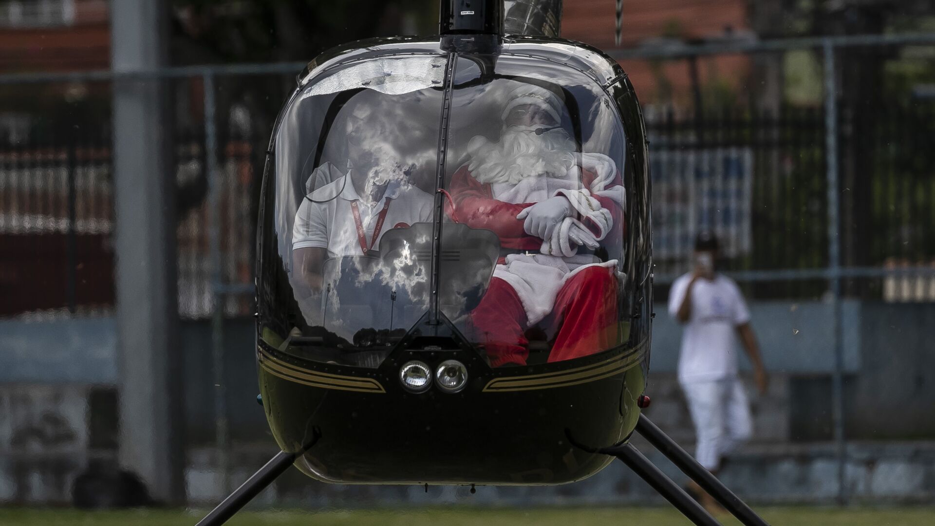 Мужчина в костюме Санта-Клауса прибывает на вертолете на празднование Рождества в Рио-де-Жанейро, Бразилия - Sputnik Молдова, 1920, 04.01.2022