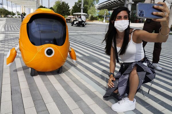 Посетительница фотографируется с роботом на Expo 2020 в Дубае. - Sputnik Молдова