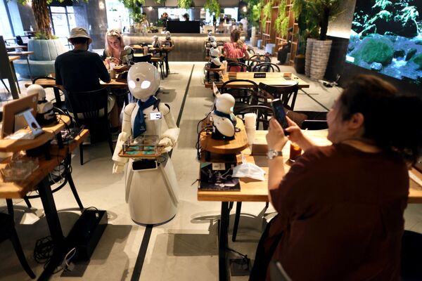 На этой фотографии, сделанной 17 августа 2021 года, робот-гуманоид разносит напитки в кафе в Токио. - Sputnik Молдова