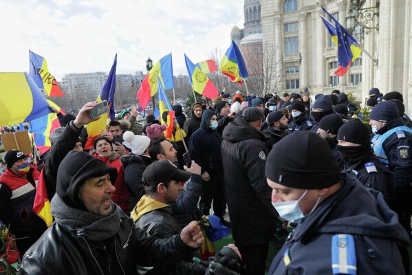 Manifestanţi aproape de lanţul de jandarmi care păzesc intrările de acces în curtea Parlamentului. - Sputnik Moldova-România