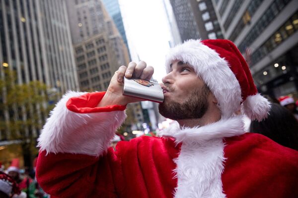 Мужчина в костюме Санта-Клауса пытается поднять себе настроение на SantaCon в Нью-Йорке. - Sputnik Молдова