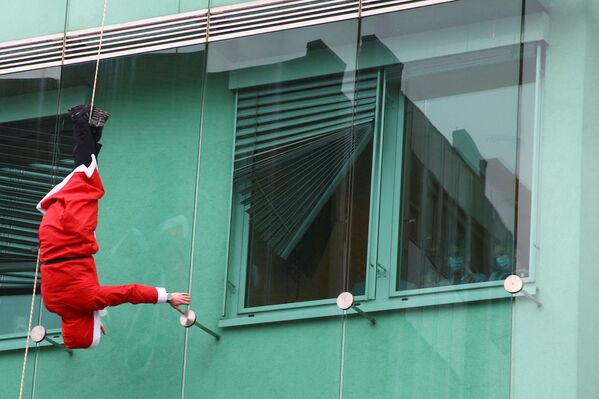 Человек в костюме Санты спускается по педиатрической клинике в Любляне, Словения. - Sputnik Молдова