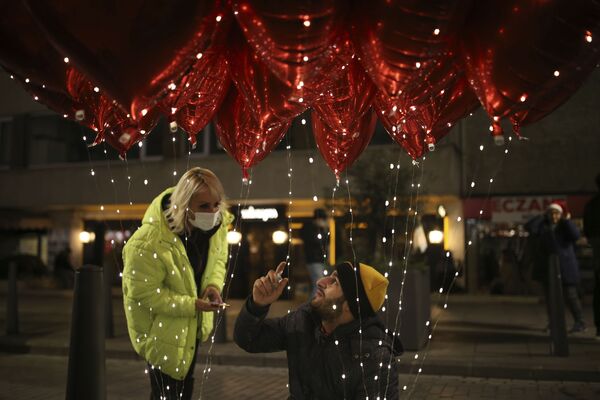 Un vânzător de baloane vorbește cu un client în Ortakoy în timpul sărbătorilor de Revelion la Istanbul, Turcia, vineri, 31 decembrie 2021. - Sputnik Moldova-România