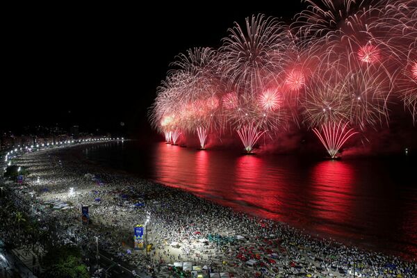Oamenii se adună pentru a vedea artificiile explodând peste plaja Copacabana în timpul sărbătorilor de Anul Nou la Rio de Janeiro, Brazilia, 1 ianuarie 2022. - Sputnik Moldova-România