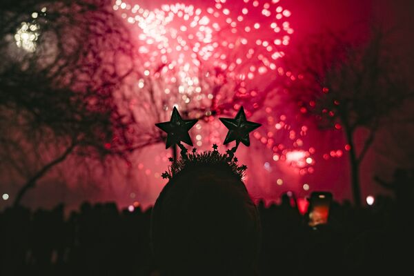 O femeie se uită la artificii în timpul sărbătorilor de Anul Nou la București, România, sâmbătă, 1 ianuarie 2022. Mii de oameni s-au adunat lângă un lac pentru a asista la un concert și a urmări artificii și un spectacol cu laser în timpul sărbătorilor de Anul Nou în capitala României. - Sputnik Moldova-România