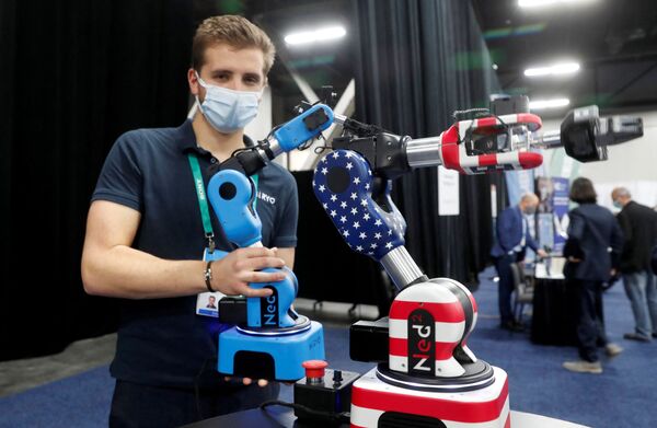 Луи Тоннер держит Ned2, коллаборативного робота, предназначенного для образования, профессионального обучения и исследований, на стенде Niryo. - Sputnik Молдова