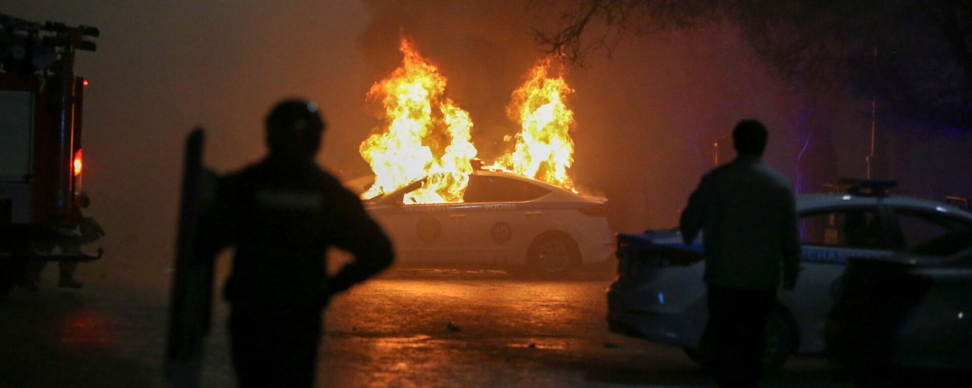 Горящая полицейская машина во время акции протеста против повышения стоимости газа в Алматы - Sputnik Moldova, 1920, 05.01.2022