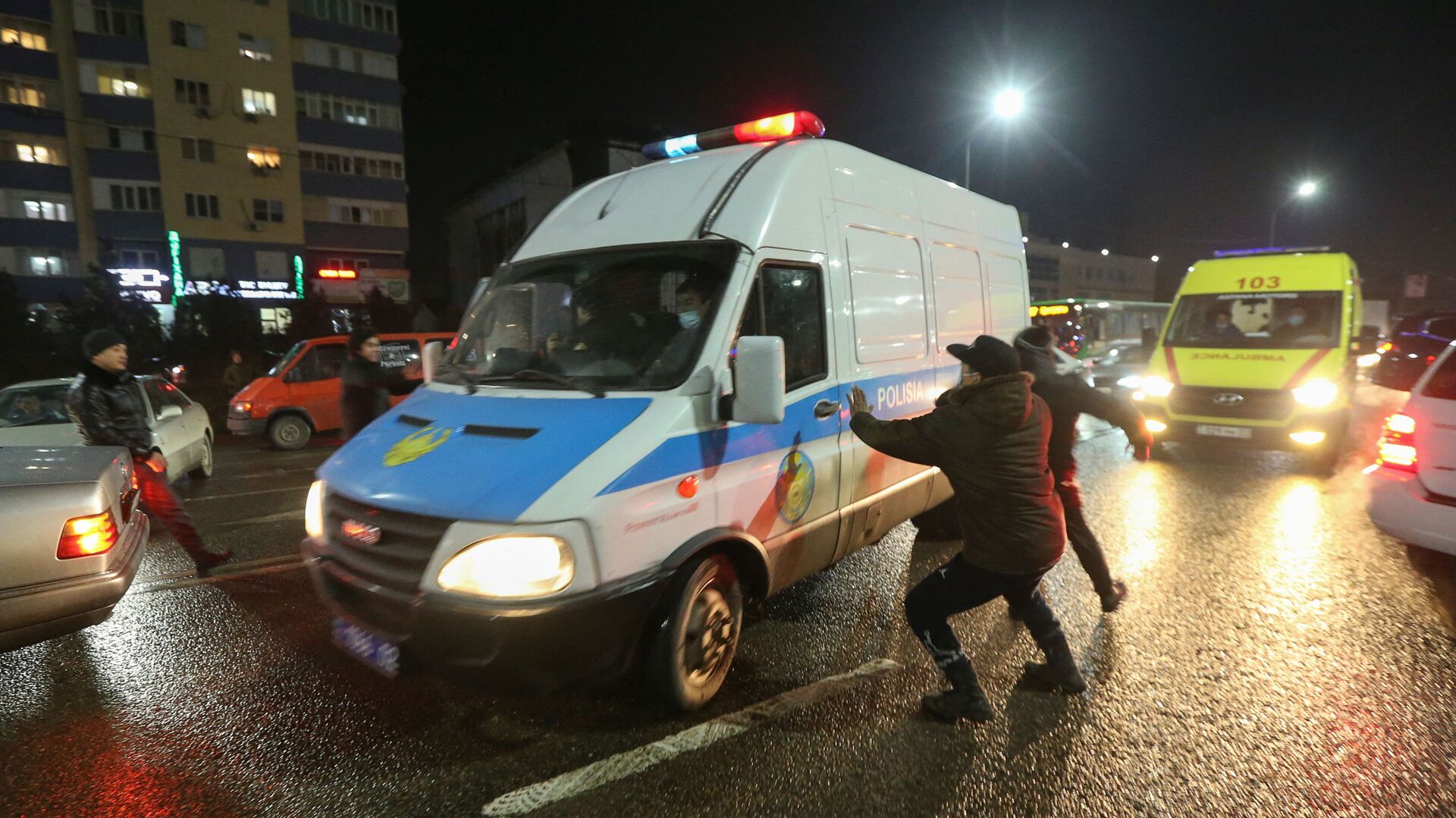 Люди нападают на полицейский микроавтобус во время акции протеста против повышения стоимости на топливо в Алматы - Sputnik Молдова, 1920, 06.01.2022