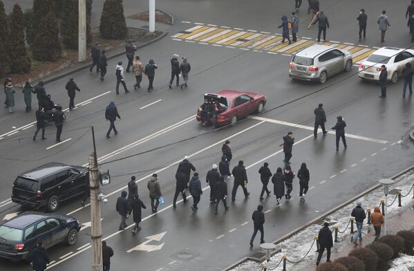 Manifestanții merg pe o stradă în timpul unui protest declanșat de creșterea prețului combustibilului în Almaty, Kazahstan, 5 ianuarie 2022. - Sputnik Moldova-România