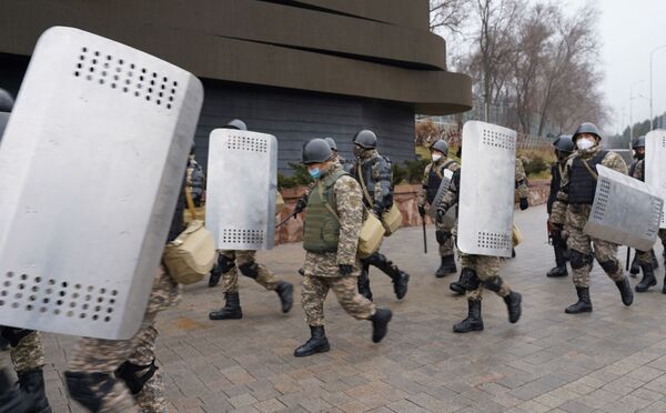 Ofițerii de poliție patrulează pe o stradă în timp ce protestele fără precedent din cauza creșterii prețurilor la energie au scăpat de sub control în Almaty pe 5 ianuarie 2022. - Sputnik Moldova-România