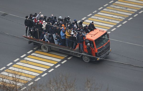 Demonstranții călătoresc cu un camion în timpul unui protest declanșat de creșterea prețului combustibilului în Almaty, Kazahstan, 5 ianuarie 2022. - Sputnik Moldova-România