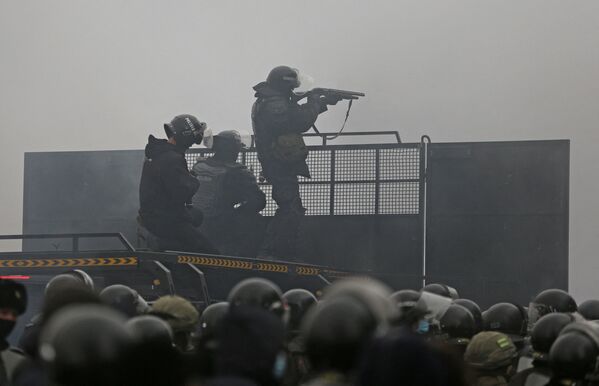 Forțele de ordine pe o baricadă în timpul unui protest declanșat de creșterea prețului combustibilului în Almaty, Kazahstan, 5 ianuarie 2022. - Sputnik Moldova-România
