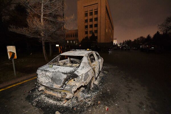 O mașină arsă în apropierea primăriei în timpul protestelor declanșate de creșterea prețului combustibilului în Almaty, Kazahstan, 5 ianuarie 2022. - Sputnik Moldova-România