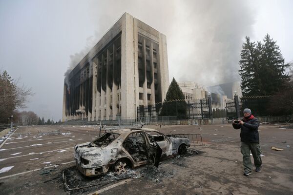 Сгоревший автомобиль перед зданием мэрии, которое было подожжено во время протестов в Алма-Ате. - Sputnik Молдова