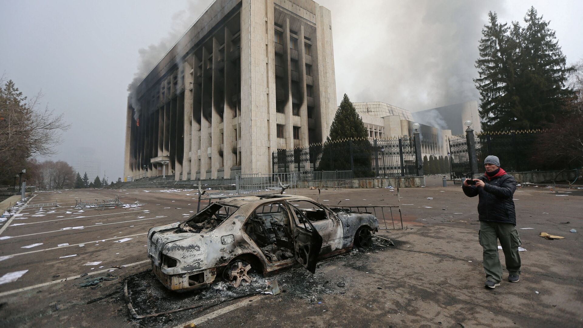 Сгоревший автомобиль перед зданием мэрии, которое было подожжено во время протестов в Алматы - Sputnik Moldova, 1920, 08.01.2022