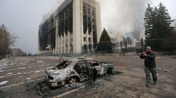 Сгоревший автомобиль перед зданием мэрии, которое было подожжено во время протестов в Алматы - Sputnik Moldova