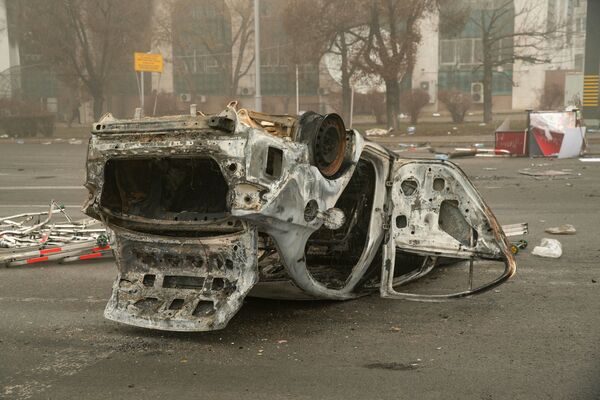 Сгоревший автомобиль на площади возле административного квартала в центре Алма-Аты. - Sputnik Молдова