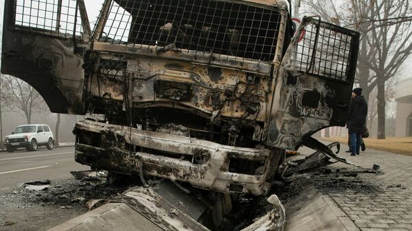 Сгоревший полицейский грузовик на улице в центре Алматы - Sputnik Moldova-România