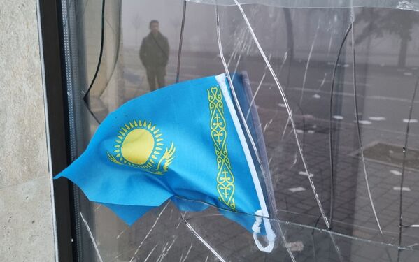 Государственный флаг Казахстана виден в разбитом окне отделения Kaspi Bank после протестов, вызванных повышением цен на топливо в Алма-Ате. - Sputnik Молдова