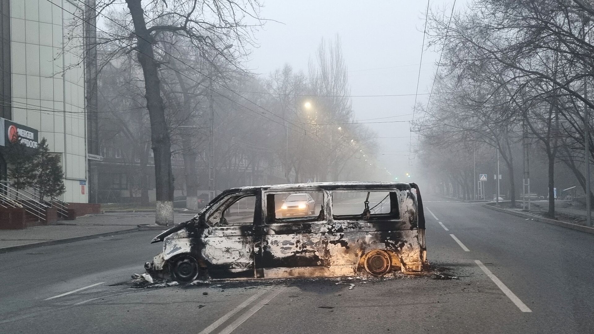 Автомобиль, сожженный во время протестов, вызванных повышением цен на топливо, на дороге в Алматы - Sputnik Moldova, 1920, 08.01.2022