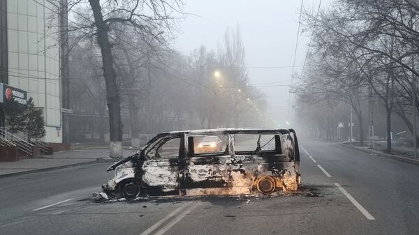 Автомобиль, сожженный во время протестов, вызванных повышением цен на топливо, на дороге в Алматы - Sputnik Молдова
