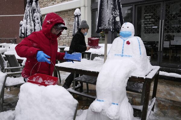 Работники ресторана лепят снеговика в форме медицинского работника в защитном костюме и маске в Пекине, Китай. - Sputnik Молдова