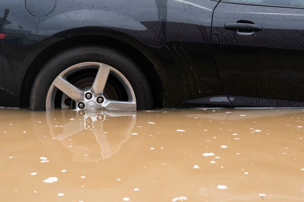 Колеса автомобиля наполовину ушли под воду. - Sputnik Молдова