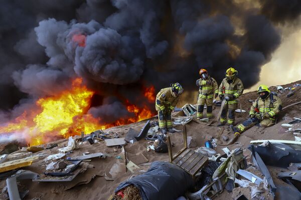 Пожарные во время отдыха от тушения мощного пожара в чилийском городе Икике. - Sputnik Молдова
